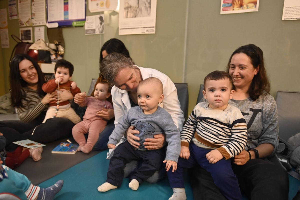 Ángeles López junto algunos de los bebés del taller del centro de salud Nicolás Peña.
