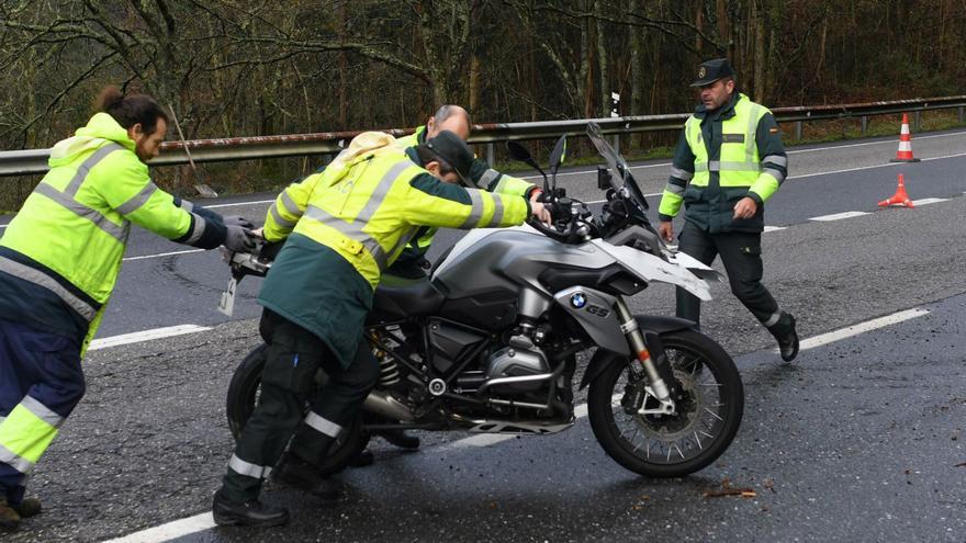 Agentes de la Guardia Civil retiran la moto del fallecido en el lugar del accidente. |  // GUSTAVO SANTOS