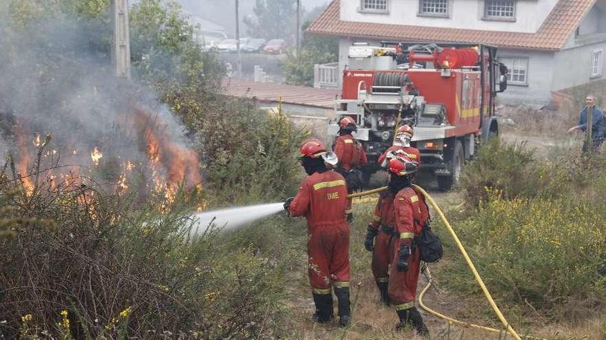 Efectivos de la UME apagan un incendio próximo a viviendas en Pazos de Borbén. // Luis Ortiz
