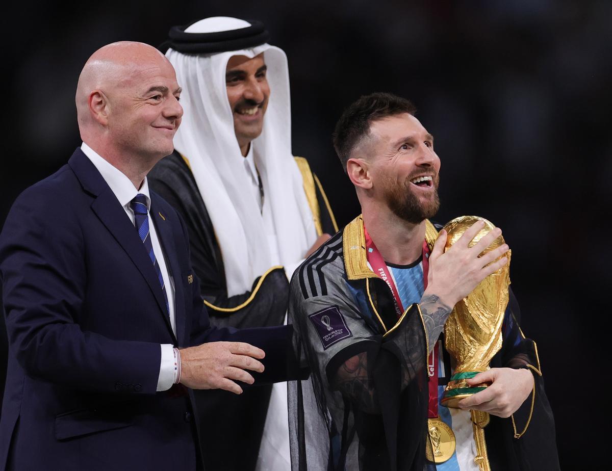 Lusail (Qatar), 18/12/2022.- Lionel Messi (R) of Argentina celebrates with the World Cup trophy next to Tamim bin Hamad Al Thani (C), the Emir of Qatar, and FIFA President Gianni Infantino (L) during the trophy ceremony after the FIFA World Cup 2022 Final between Argentina and France at Lusail stadium, Lusail, Qatar, 18 December 2022. (Mundial de Fútbol, Francia, Estados Unidos, Catar) EFE/EPA/Friedemann Vogel