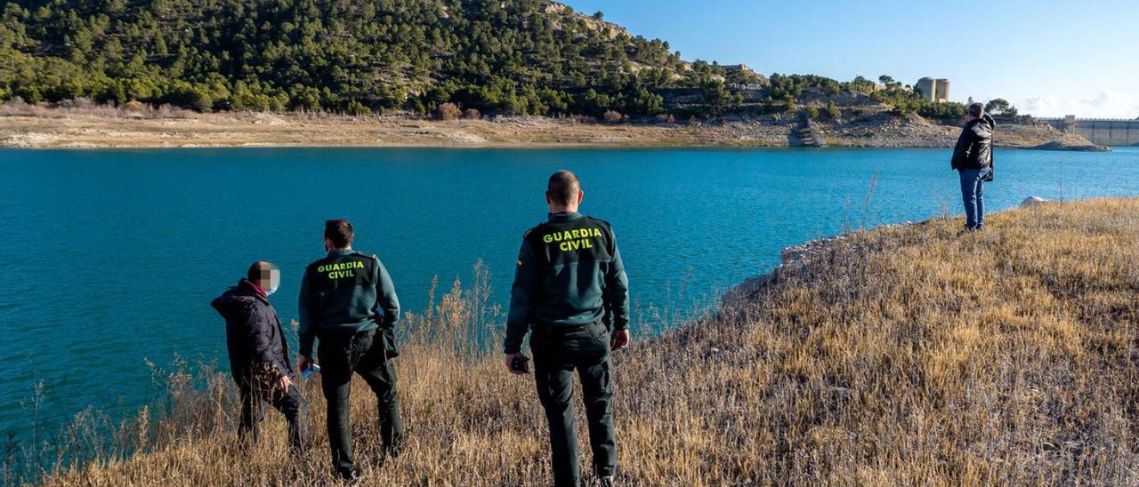 Técnicos y efectivos de la Guardia Civil buscan el helicóptero hundido en el Amadorio el jueves.  | DAVID REVENGA