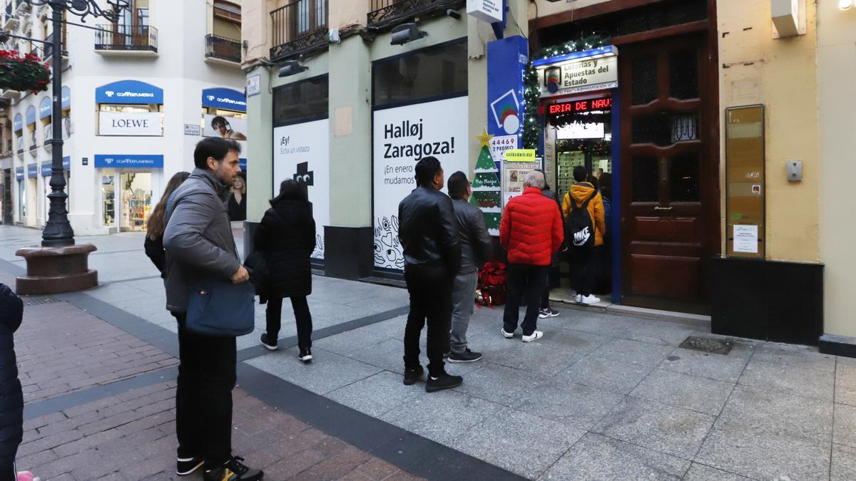 Varias personas hacen fila para comprar lotería en una administración de la calle Alfonso de Zaragoza, el pasado viernes.