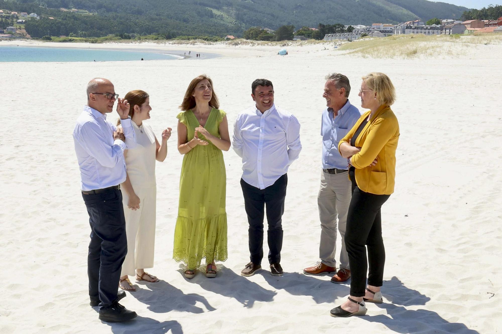 A conselleira e o alcalde, no centro, na praia urbana de Laxe.