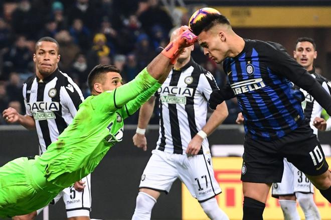 El portero argentino del Udinese Juan Musso intenta detener el remate de cabeza del jugador del Inter de Milán Lautaro Martinez durante el partido de la Serie A italiana entre el Inter de Milán y el Udinese en San Siro, Milán