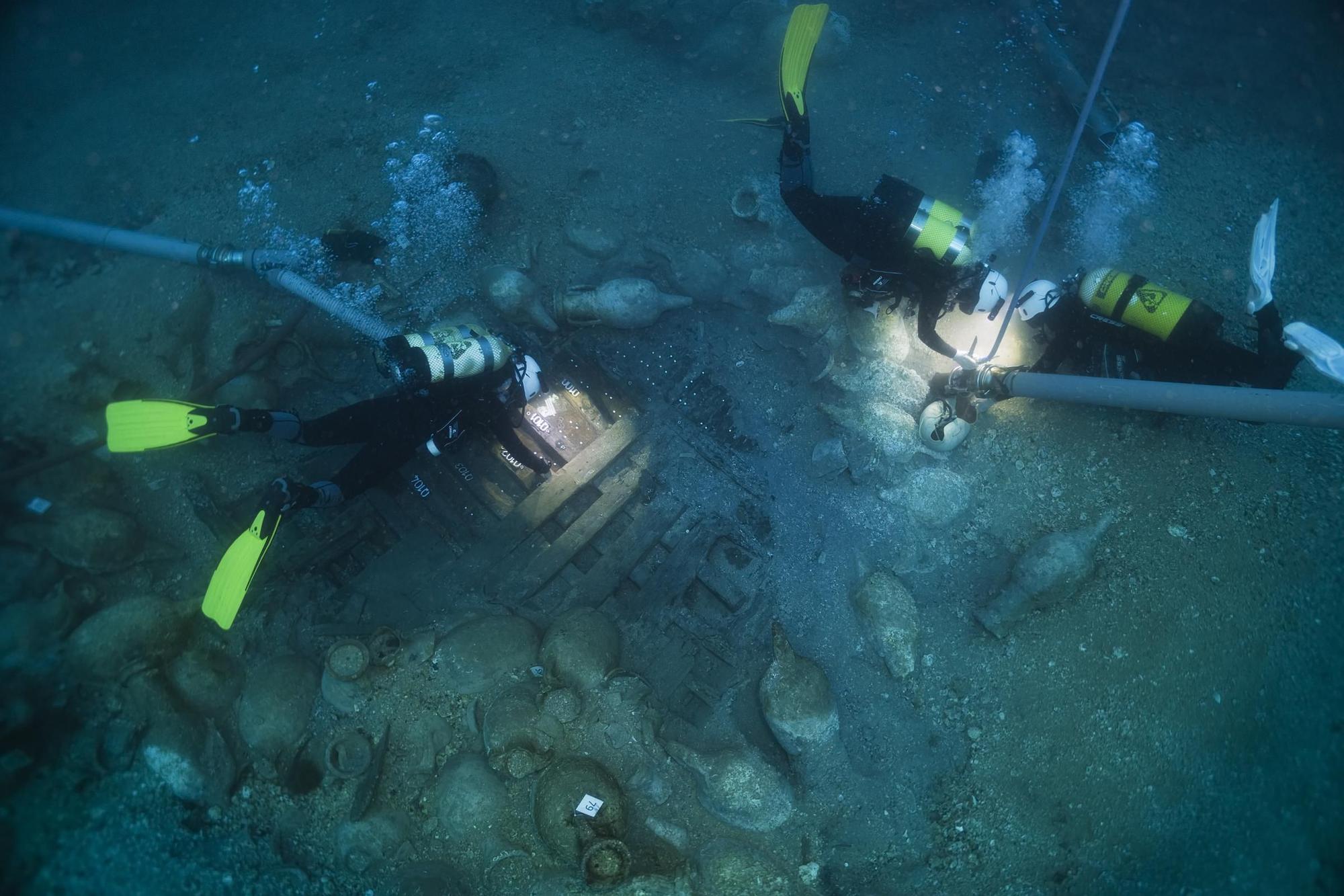 Els arqueòlegs estudiant les fustes del vaixell romà del segle I aC enfonsat durant un temporal a les illes Formigues