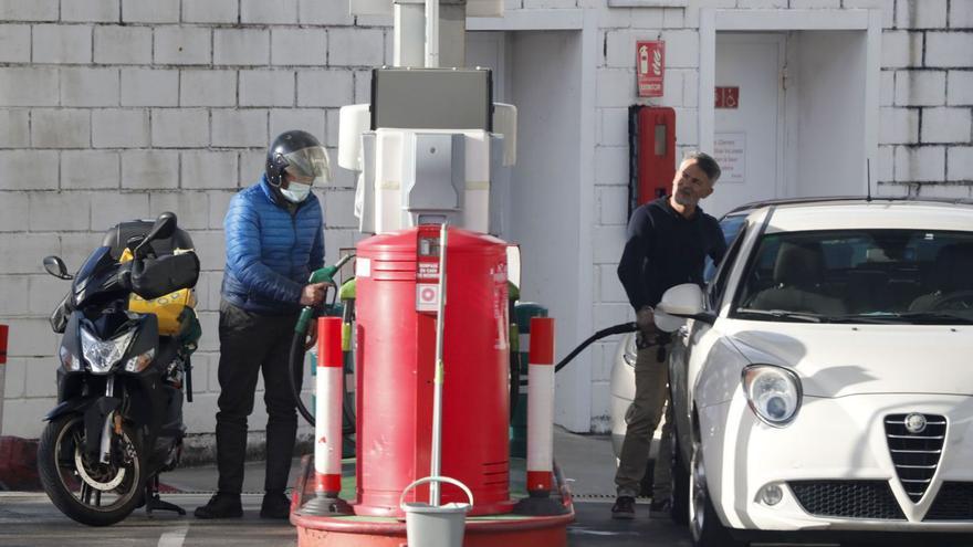 Dos conductores llenan los depósitos de sus vehículos en una gasolinera de Vigo.