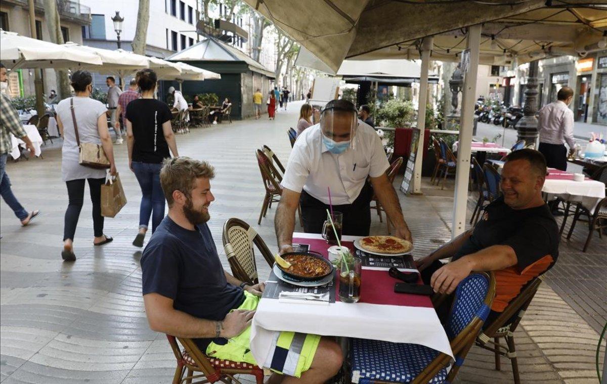 Clientes en una terraza de la Rambla.