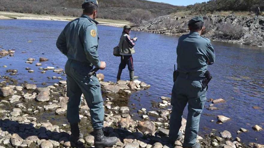 Agentes del Seprona conversan con un pescador en Cernadilla.