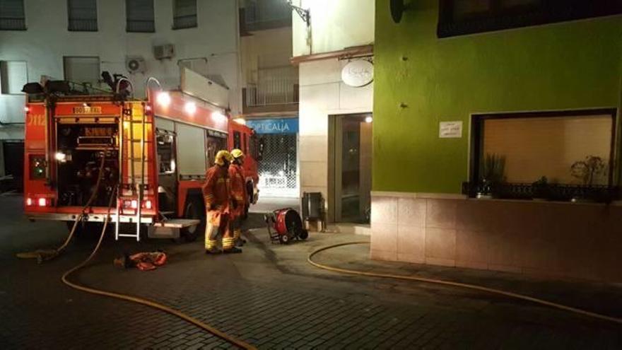 Los bomberos desalojan tres pisos por el incendio en un bar de Benigànim