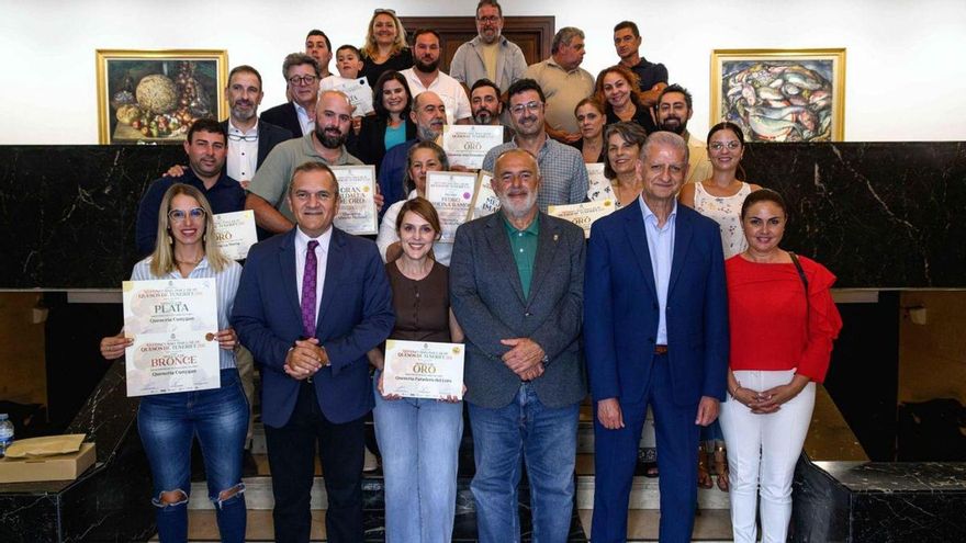 Un grupo de los premiados posan con las autoridades en las escaleras del Cabildo.