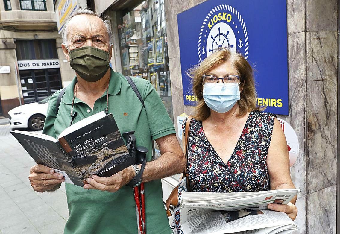 Juan Albert y María Luisa de la Rosa, con el periódico y el libro, en Gijón. | MARCOS LEÓN 