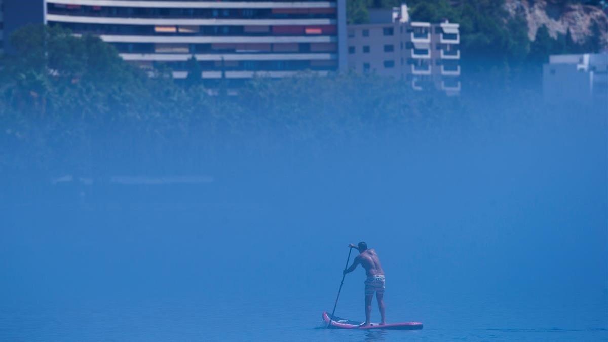 Un hombre practica padel surf en la playa de la Malagueta (Málaga) en medio de la niebla, el 19 de agosto del 2020