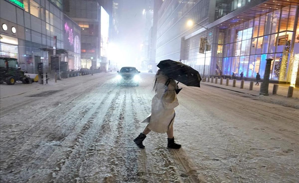 Un viandante con paraguas, bajo la nieve, en Times Square, Nueva York, el 17 de diciembre del 2020.