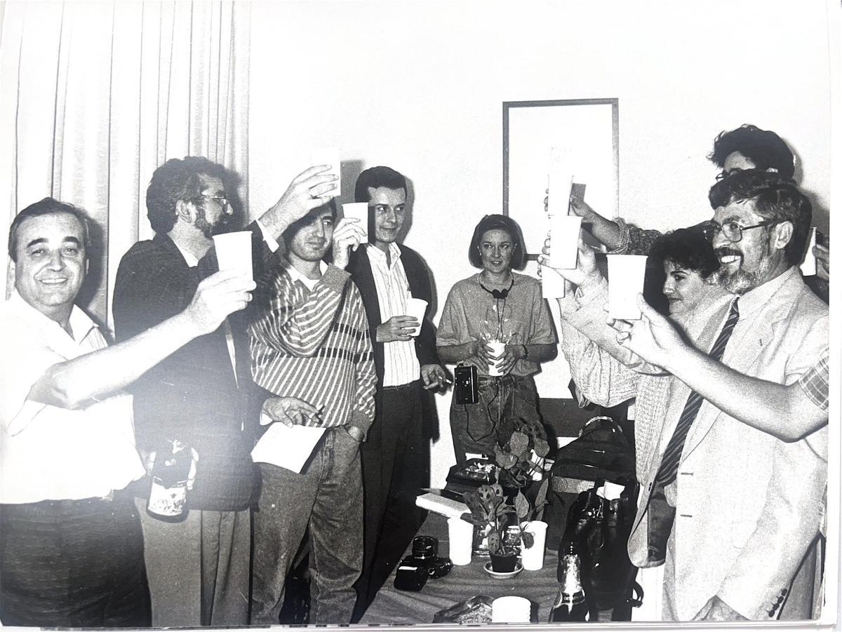 Rafael García Contreras y Ernesto Caballero (en los dos extremos) brindan con compañeros y periodistas en una noche electoral en la sede del PCE.