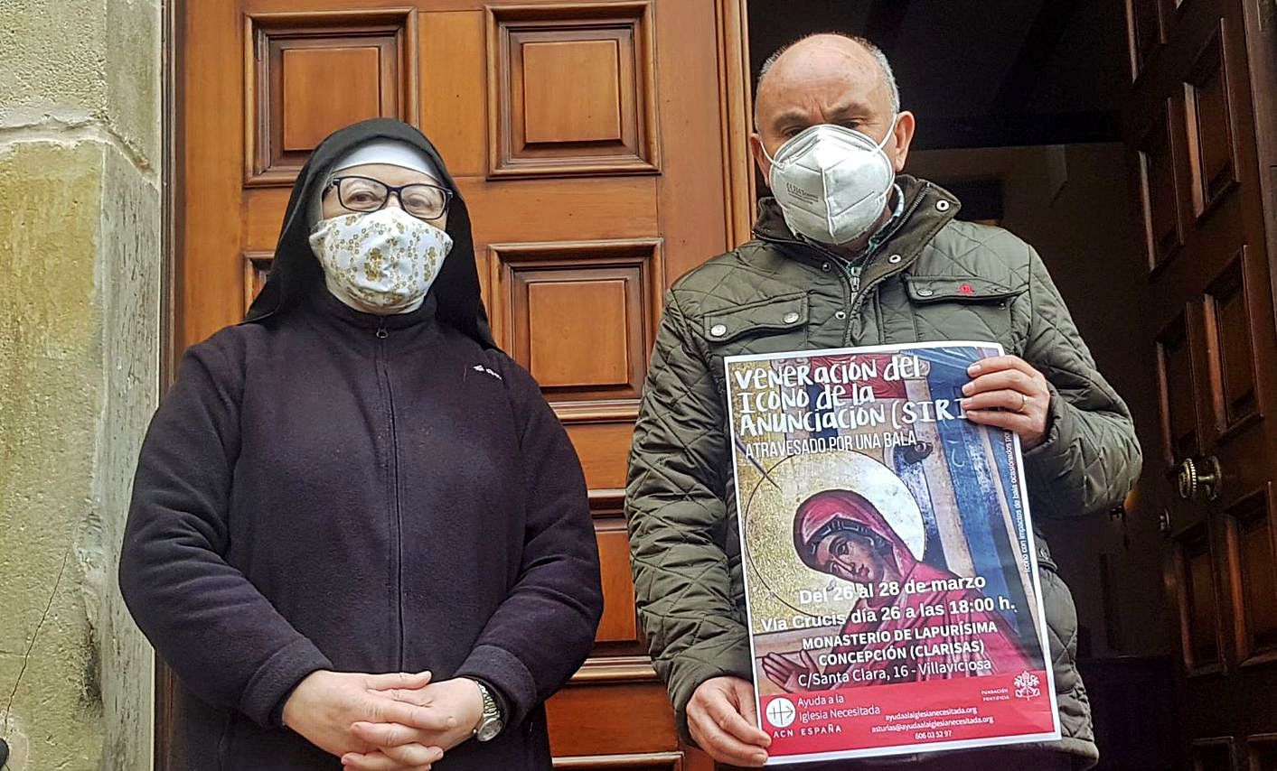 La abadesa María Luisa Picado Amandi y el  párroco Gonzalo José Suárez, en el convento de las Clarisas, con el cartel de la veneración del icono de la Anunciación (Siria).