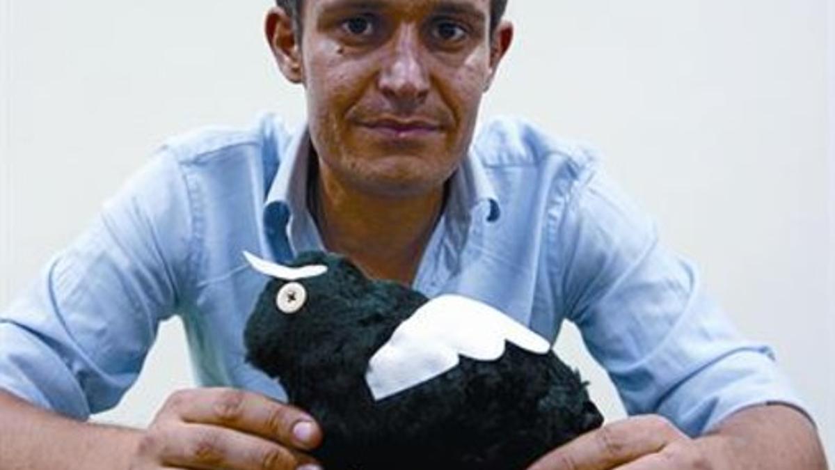 Leonardo Anselmi sostiene un toro alado de peluche.