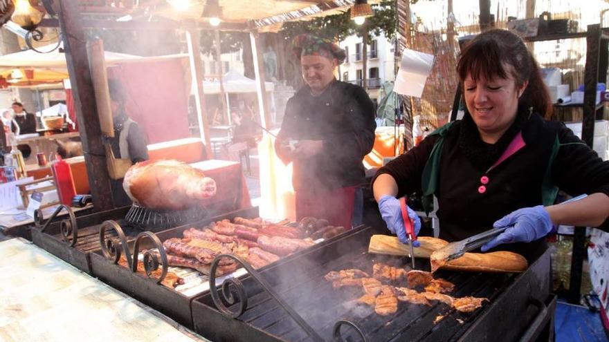 La plancha, a pleno rendimiento con manjares del cerdo, en un puesto de comida del mercado.