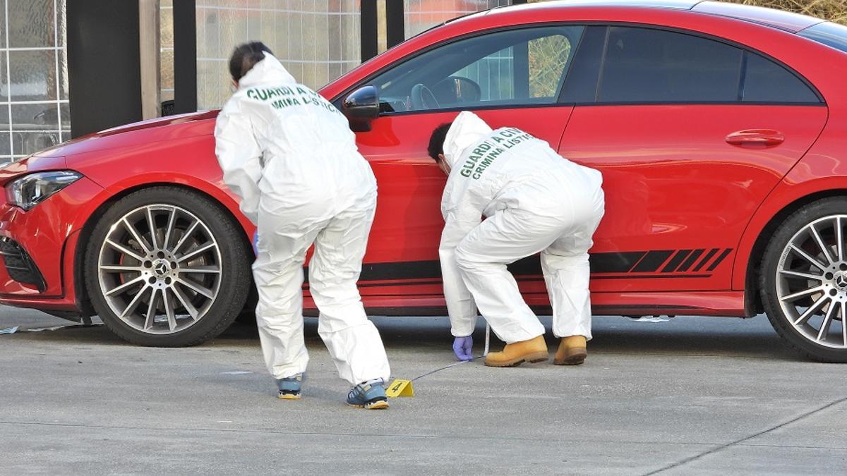 Dos guardias de criminalística recogen pruebas tras el tiroteo de Tamallancos.