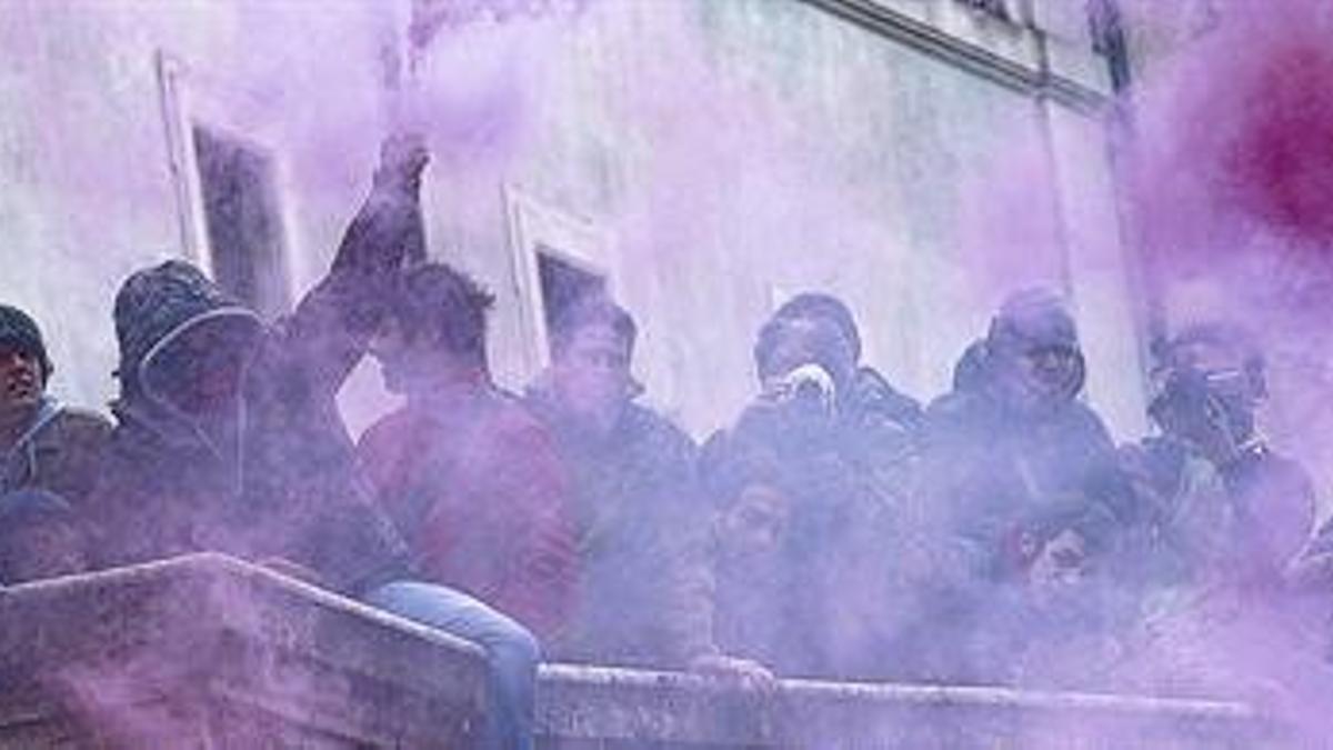 Estudiantes italianos con bengalas de humo de colores, ayer durante la manifestación en el centro de Roma.