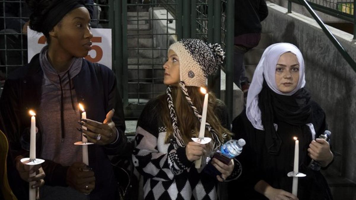 Tres jóvenes participan en una vigilia en memoria de las víctimas del tiroteo de San Bernardino.