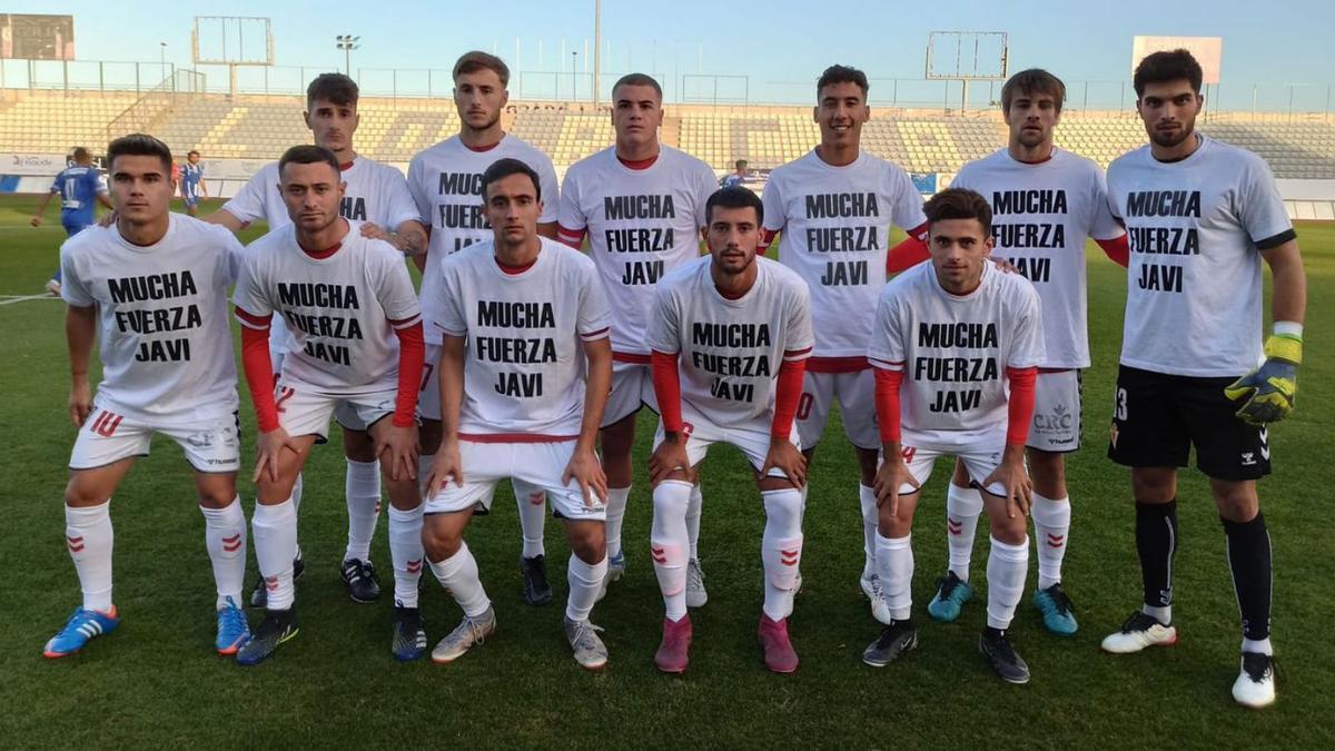 Los jugadores del Real Murcia Imperial lucen un mensaje de apoyo a Javi en sus camisetas. | REAL MURCIA CF