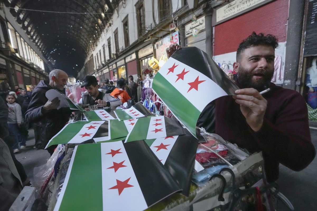 Un hombre vende banderas de la oposición rebelde siria en el mercado de Al Hamidiyeh, en Damasco, este martes. Un hombre vende banderas de la oposición rebelde siria en el mercado de Al Hamidiyeh, en Damasco, este martes.