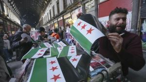 Un hombre vende banderas de la oposición rebelde siria en el mercado de Al Hamidiyeh, en Damasco, este martes.