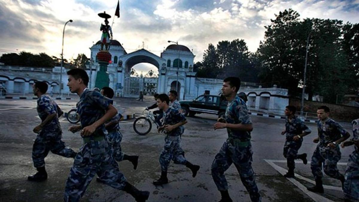 Un grup de policies nepalesos corren al voltant de l’edifici del Govern a Kàtmandu.