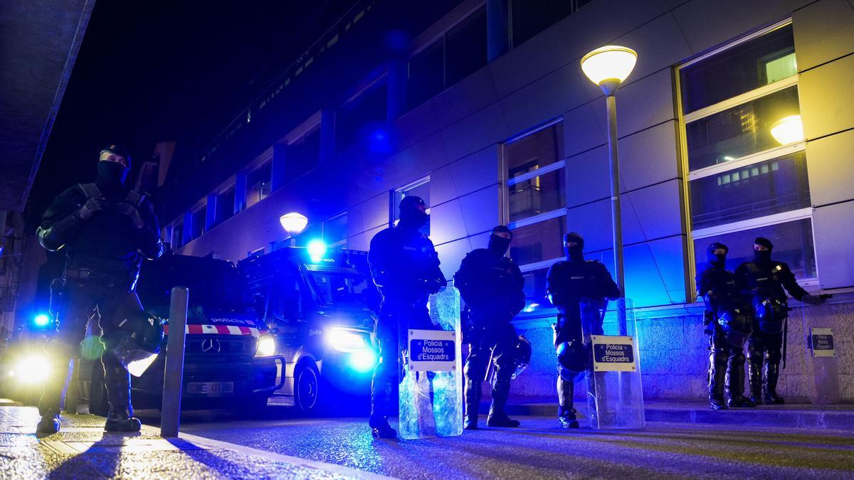 Agentes de los Mossos custodian la comisaria después de detener a dos personas en el barrio de Font de la Pólvora.