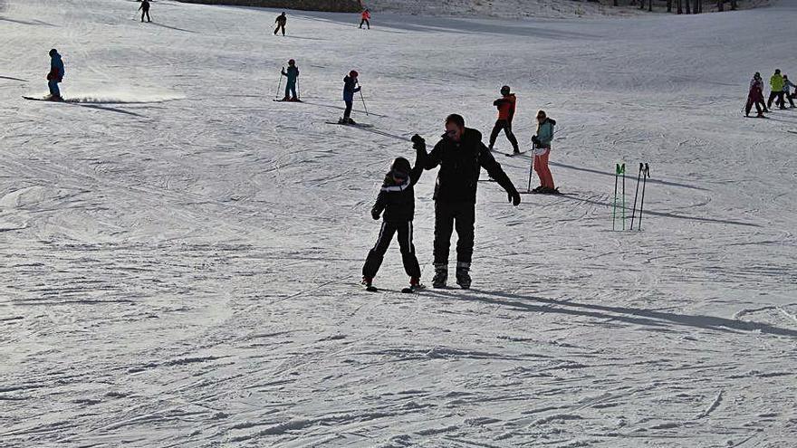 Un pare i un fill esquiant al Port del Comte al desembre