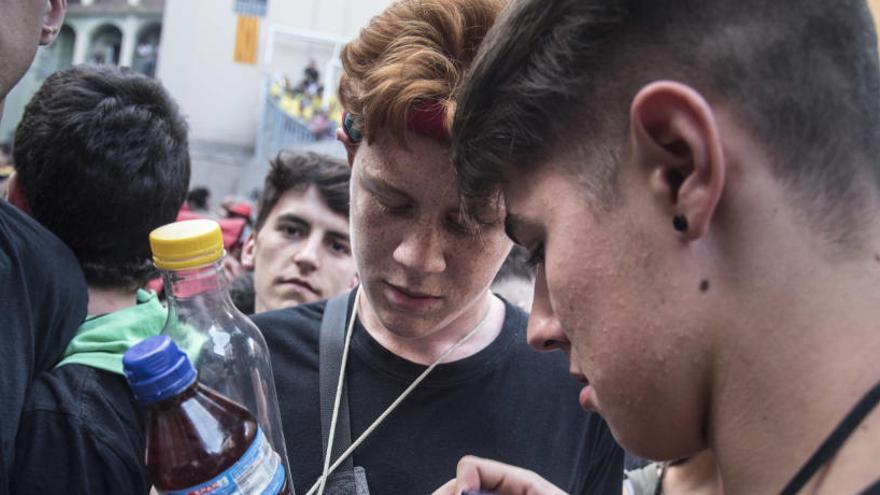 Joves amb ampolles de plàstic amb beguda al passacarrers del dimecres de Corpus del 2019