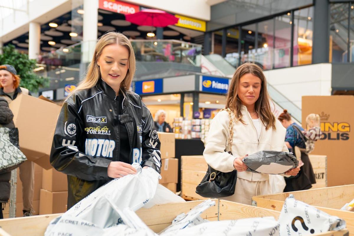 Dos clientas eligen sus paquetes en la tienda efímera de Amazon de King Colis.