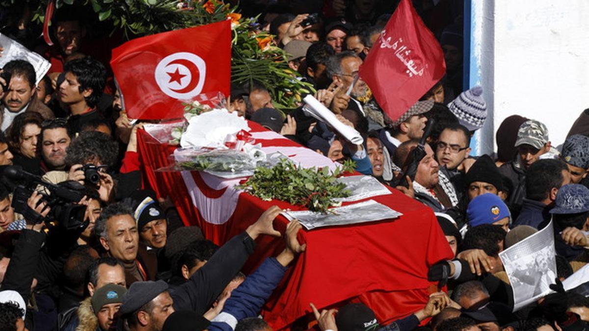 Tunecinos portan el ataúd con los restos mortales del opositor Chukri Bel Aid durante su multitudinario funeral en la capital tunecina, el viernes.