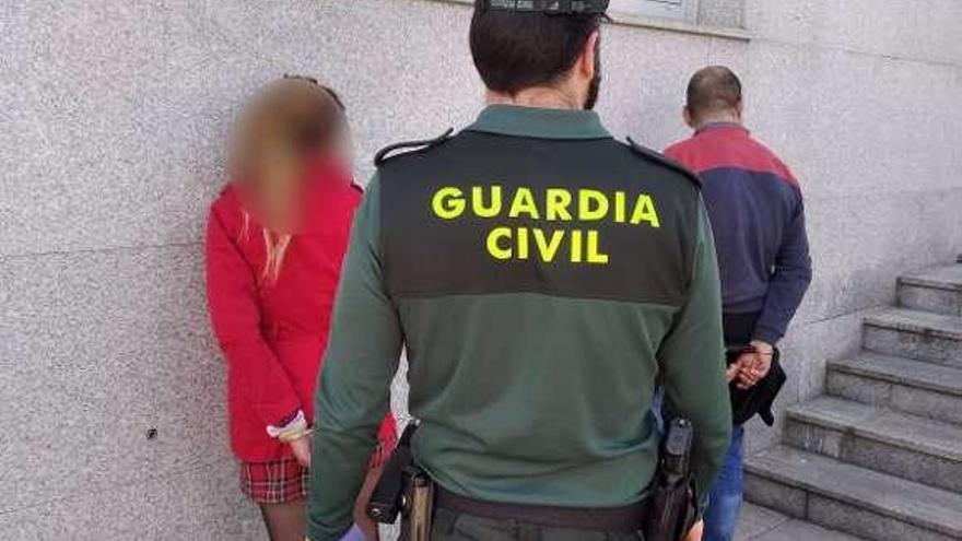 Los dos detenidos, junto a un agente. // Guardia Civil