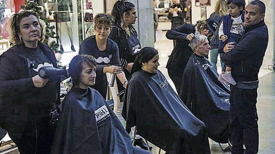 Tres peluqueras cortando el pelo en la plaza rei Joan Carles I, ayer.