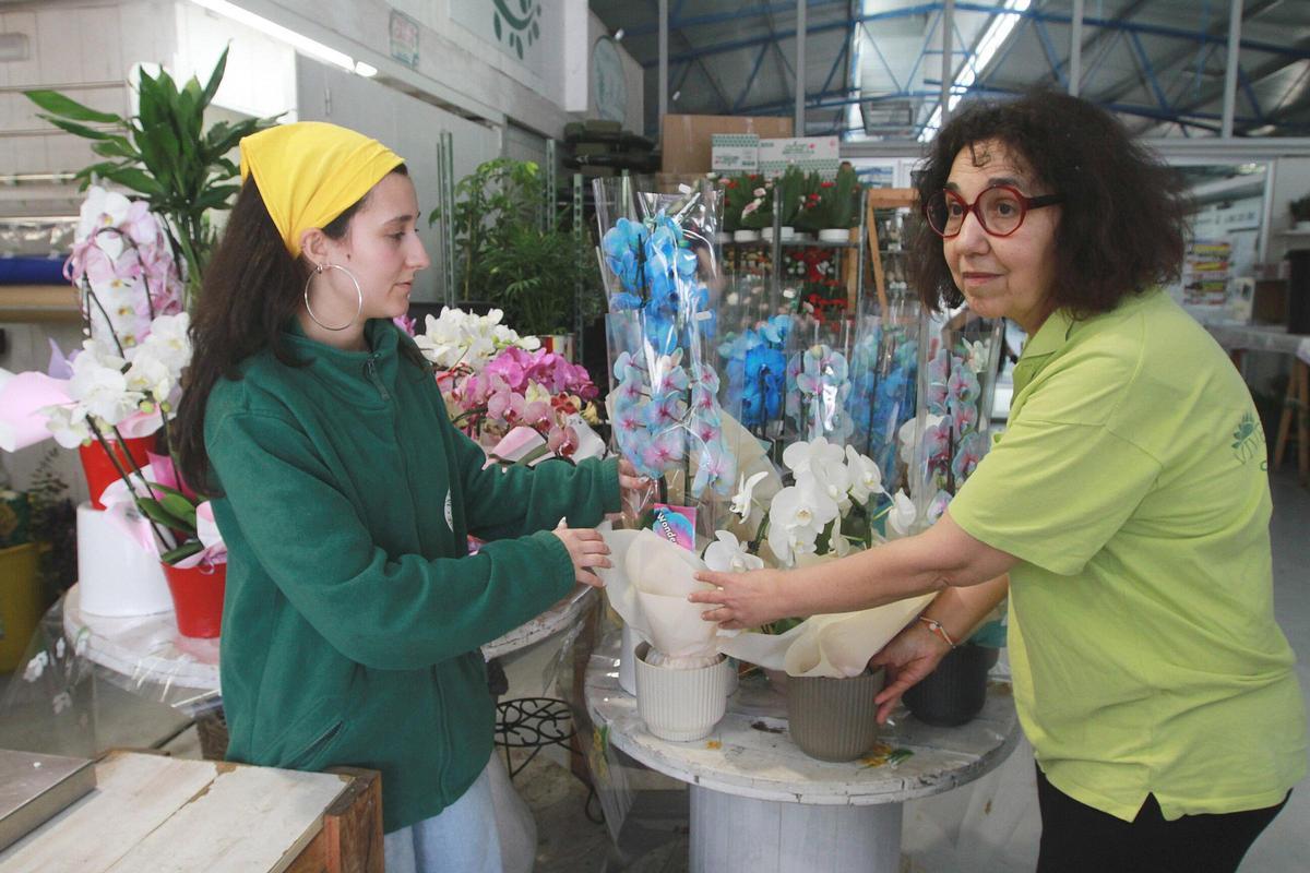 Trabajando en día festivo para apurar los encargos florales para el domingo en la Plaza de Abastos