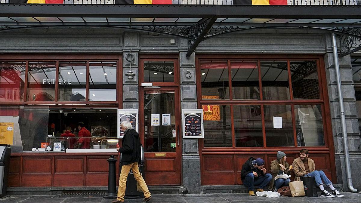 Jóvenes en la plaza Gran Place de Bruselas, ayer, con bares y restaurantes cerrados. | EFE