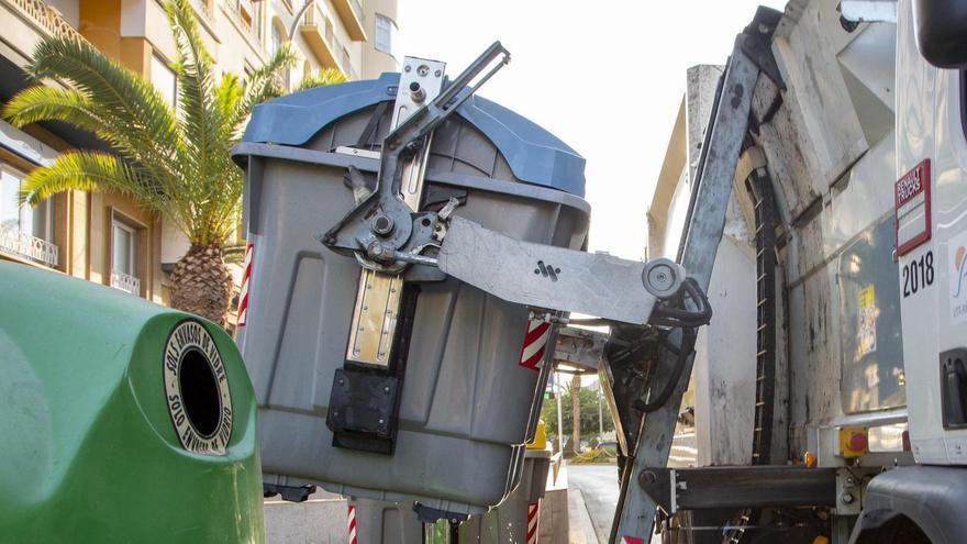 Un camión vacía los contenedores en la avenida de la Estación de Alicante.
