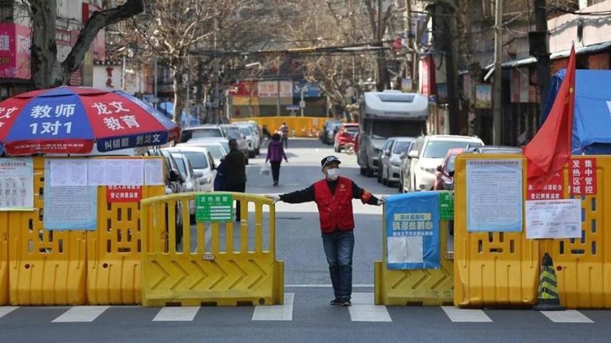 Un voluntario cierra el acceso a un barrio de Wuhan, en China, el pasado 15 de marzo.