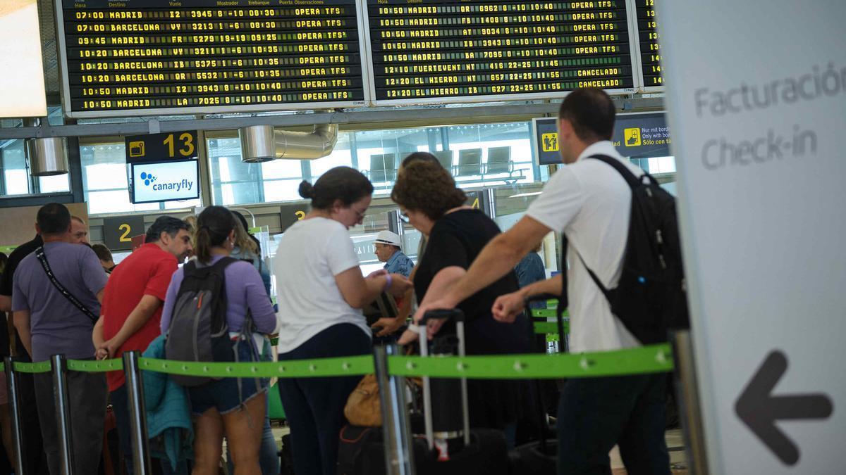 Los pasajeros hacen cola para facturar sus equipajes en el aeropuerto.