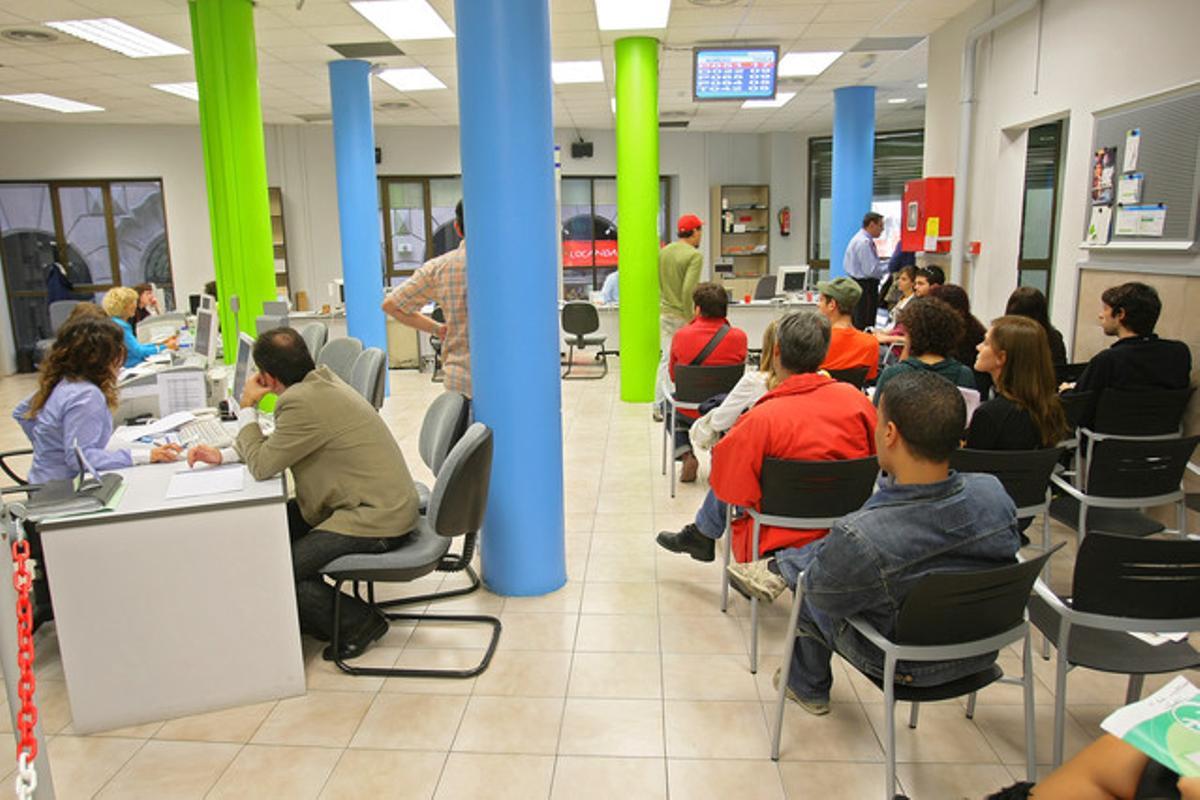 Diverses persones esperen el seu torn en una oficina de treball del barri Gòtic de Barcelona.