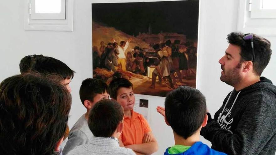 El maestro Fernando Fernández explica a los alumnos detalles de la obra de Goya &quot;Los fusilamientos del 2 de mayo&quot;, ayer, en Villayón.