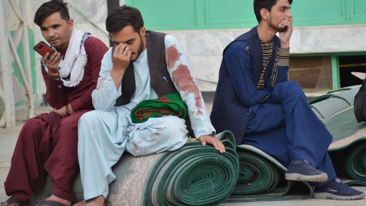 Varios hombres en el exterior de la mezquita chií de Kandahar tras el ataque suicida, este viernes.