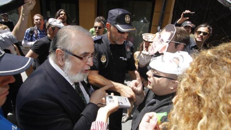 Policías escoltan al presidente de la Audiencia Provincial, Luis Brualla, rodeado de simpatizantes del 15-M.