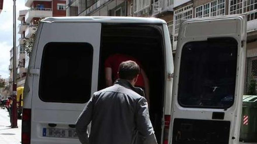 Un agente introduce parte del botín en una furgoneta.