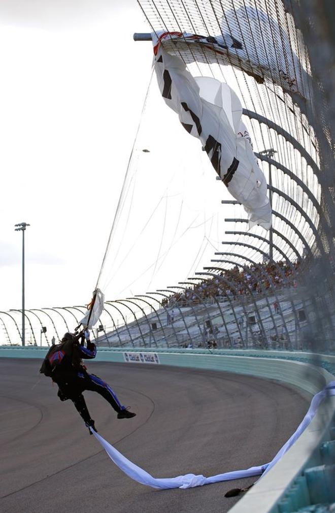 Un paracaidista está atrapado en la valla durante las ceremonias previas a la carrera para la Ecosterster 400 de la Copa NASCAR de Monster Energy en el circuito Homestead-Miami Speedway en Homestead, Florida.