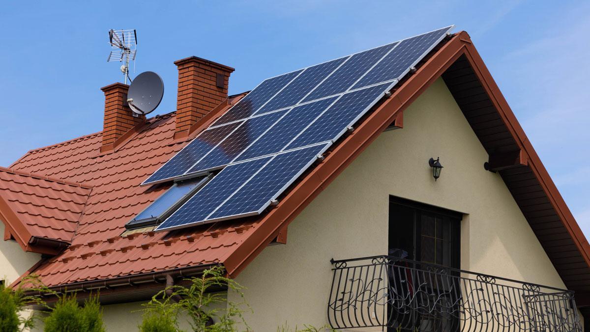 Una casa unifamiliar con placas solares en el tejado. Una casa unifamiliar con placas solares en el tejado.