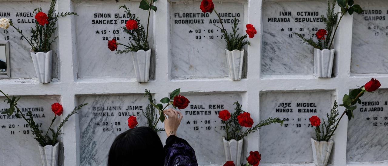 Una mujer en Chile deposita flores en las tumbas de desaparecidos bajo la dictadura de Pinochet.