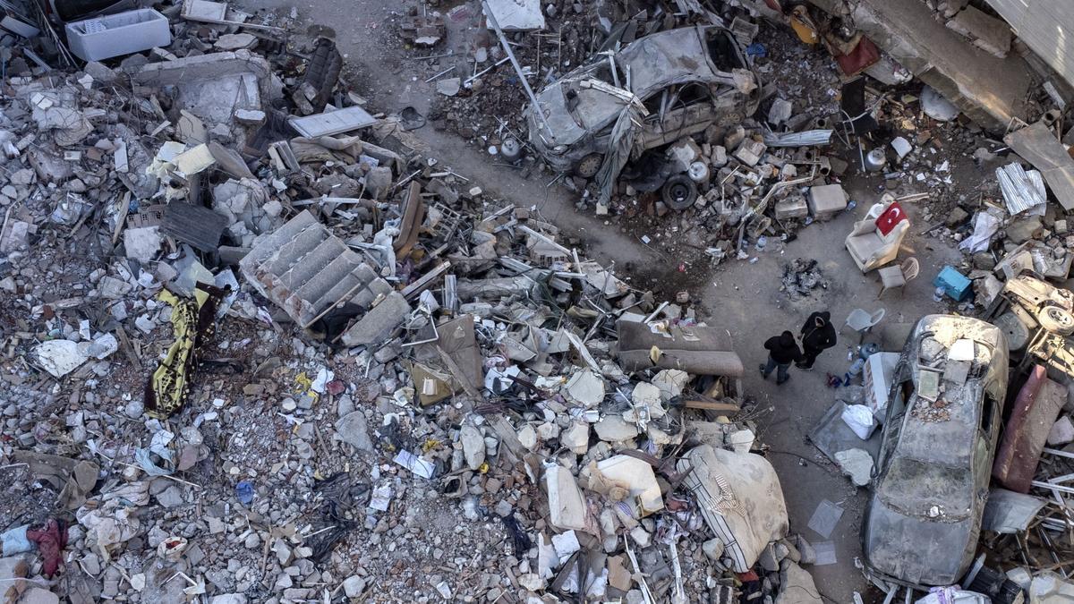 Una fotografía aérea tomada por un dron muestra a personas junto a un edificio derrumbado tras un fuerte terremoto en Hatay, Turquía, el 11 de febrero de 2023. 