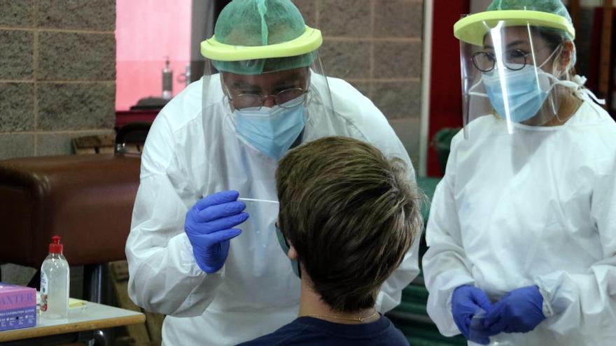 Personal sanitari extreu mostres per a PCR en una escola